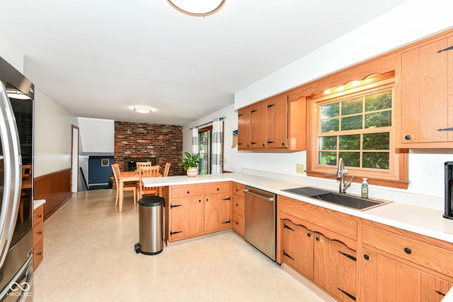 7014 Creekside Ln, Indianapolis, IN 46220 - kitchen with stainless steel appliances, light countertops, a peninsula, wainscoting, and a fireplace