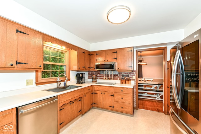 7014 Creekside Ln, Indianapolis, IN 46220 - kitchen with stainless steel appliances, light countertops, backsplash, brown cabinetry, and light floors