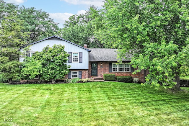 7014 Creekside Ln, Indianapolis, IN 46220 - split level home featuring brick siding, a front yard, a chimney, and a shingled roof