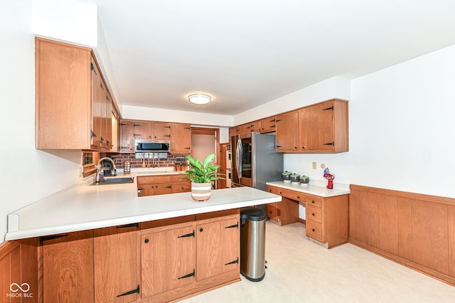 7014 Creekside Ln, Indianapolis, IN 46220 - kitchen featuring appliances with stainless steel finishes, light countertops, a peninsula, tasteful backsplash, and a wainscoted wall