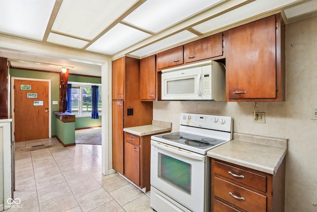 202 W Elbert St, Indianapolis, IN 46217 - kitchen featuring white appliances, light countertops, brown cabinets, and light tile patterned floors