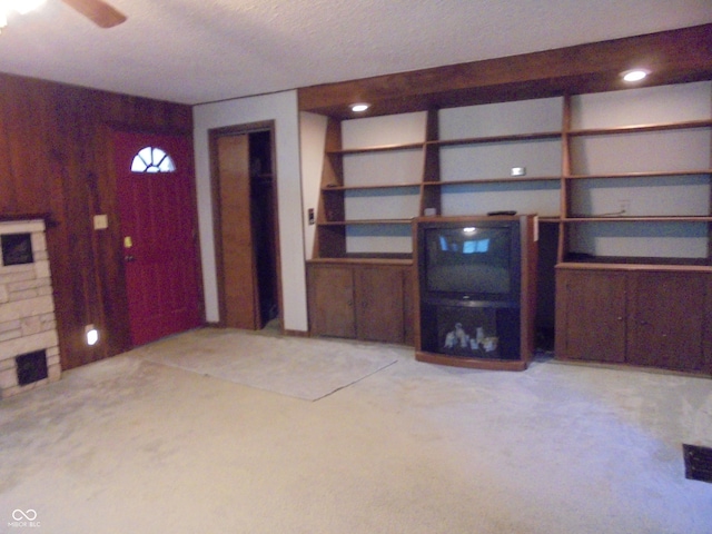 219 S Main St, Modoc, IN 47358 - unfurnished living room with light colored carpet, built in shelves, a textured ceiling, and a ceiling fan