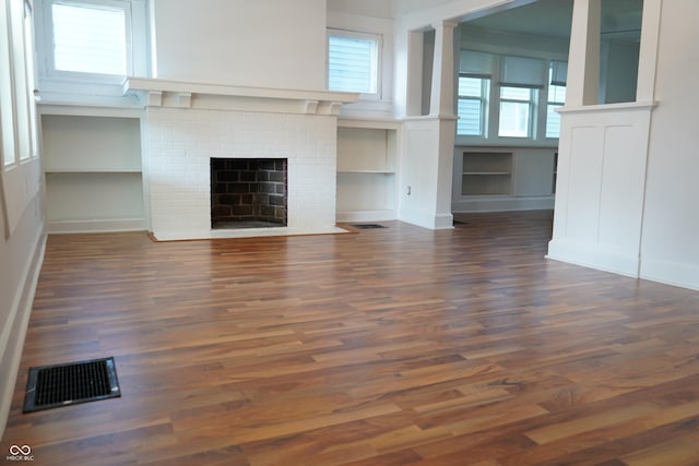 3554 N Illinois St, Indianapolis, IN 46208 - unfurnished living room featuring a fireplace, wood finished floors, and a decorative wall