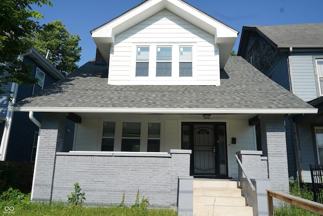 3554 N Illinois St, Indianapolis, IN 46208 - bungalow-style home with roof with shingles, covered porch, and brick siding