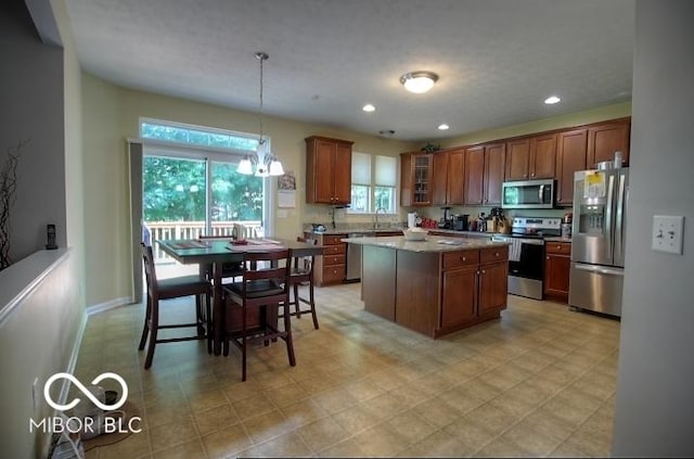 11275 Catalina Dr, Fishers, IN 46038 - kitchen featuring stainless steel appliances, glass insert cabinets, a center island, hanging light fixtures, and recessed lighting