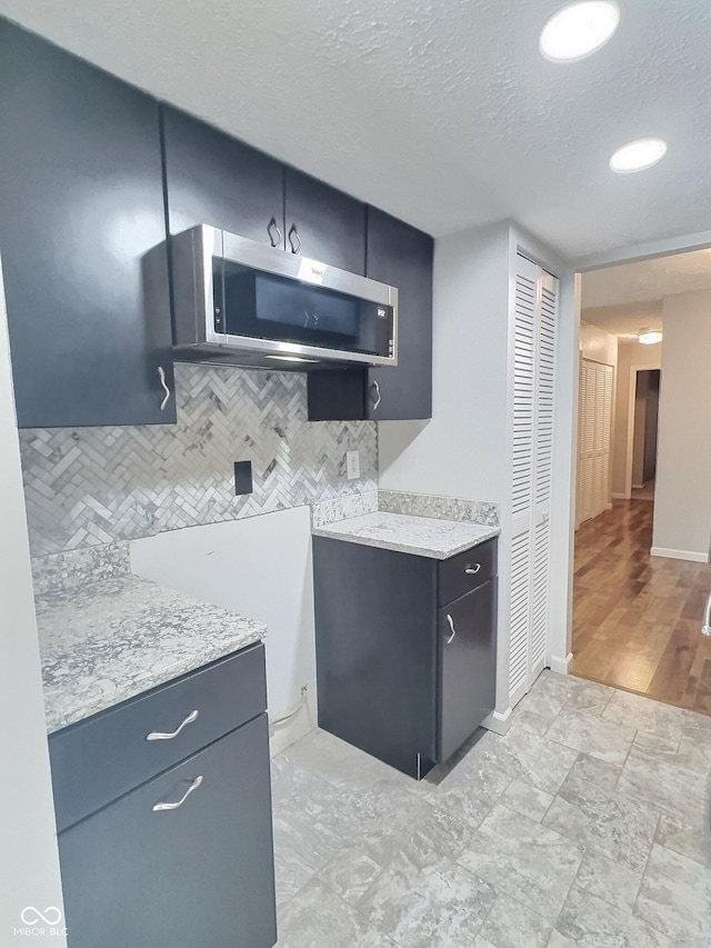 2975 Two Worlds Dr, Columbus, IN 47201 - kitchen with stainless steel microwave, tasteful backsplash, and a textured ceiling