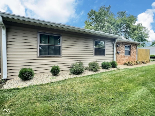2975 Two Worlds Dr, Columbus, IN 47201 - view of side of home featuring a yard and brick siding