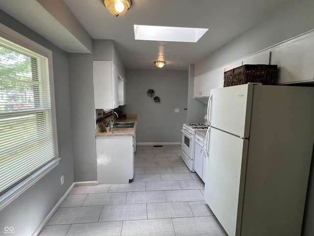 1726 N Linwood Ave, Indianapolis, IN 46218 - kitchen featuring white appliances, a skylight, white cabinets, light countertops, and light tile patterned floors