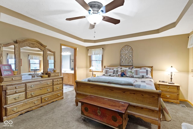 1530 Danaher St, Indianapolis, IN 46217 - bedroom featuring light carpet, a tray ceiling, ensuite bath, and a ceiling fan
