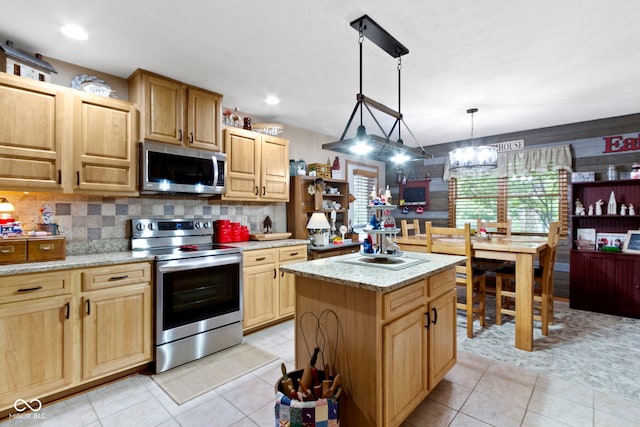 1530 Danaher St, Indianapolis, IN 46217 - kitchen featuring stainless steel appliances, a center island, backsplash, light stone counters, and light tile patterned floors