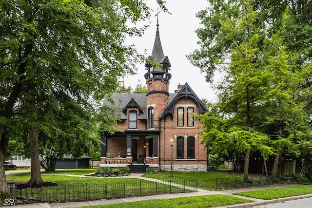 5631 University Ave, Indianapolis, IN 46219 - victorian home with a porch, brick siding, a fenced front yard, and a chimney