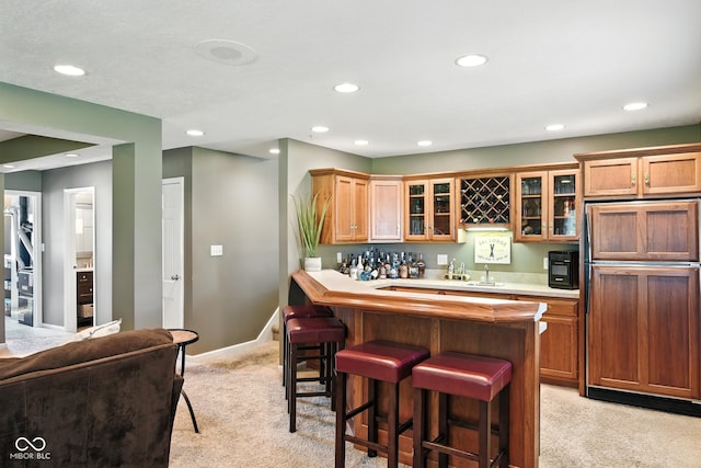 3191 W 246th St, Sheridan, IN 46069 - kitchen with paneled refrigerator, light colored carpet, a kitchen bar, recessed lighting, and glass insert cabinets