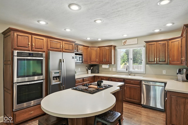 3191 W 246th St, Sheridan, IN 46069 - kitchen featuring stainless steel appliances, a breakfast bar area, wood finished floors, light countertops, and recessed lighting