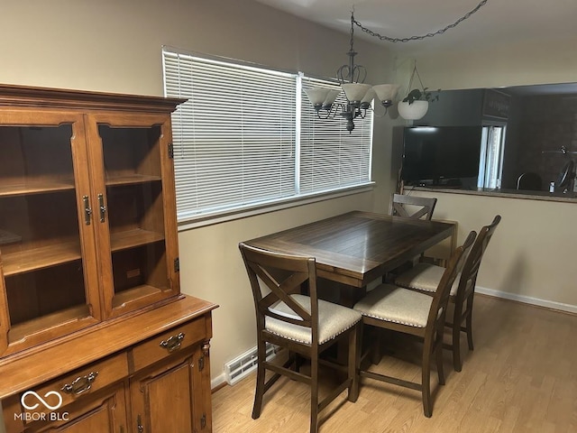 4728 S Eaton Ave, Indianapolis, IN 46239 - dining room with light wood finished floors and a chandelier