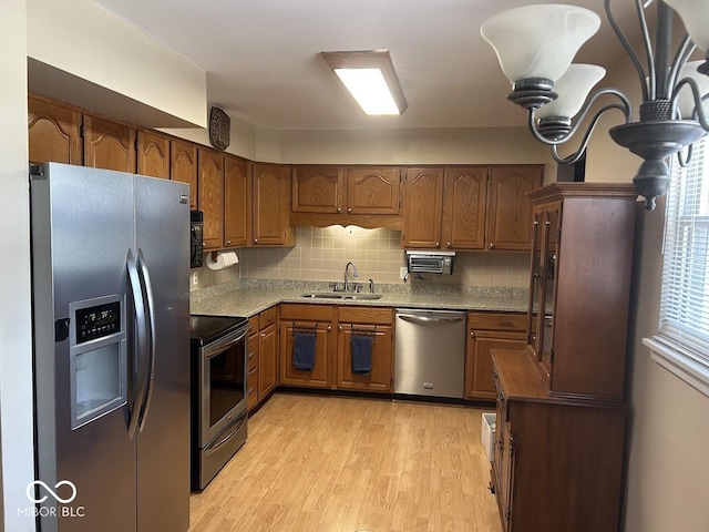 4728 S Eaton Ave, Indianapolis, IN 46239 - kitchen featuring stainless steel appliances, light wood-type flooring, brown cabinetry, and backsplash