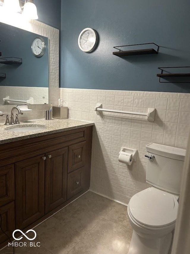 4728 S Eaton Ave, Indianapolis, IN 46239 - bathroom featuring tile walls, vanity, and wainscoting