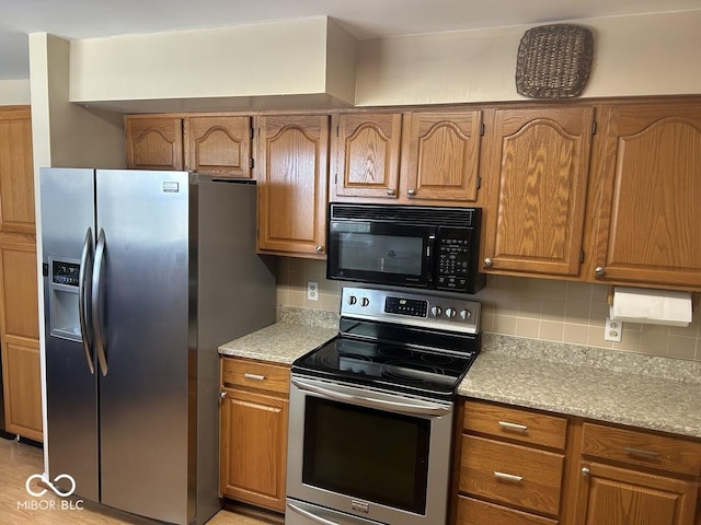 4728 S Eaton Ave, Indianapolis, IN 46239 - kitchen with stainless steel appliances, decorative backsplash, and brown cabinets