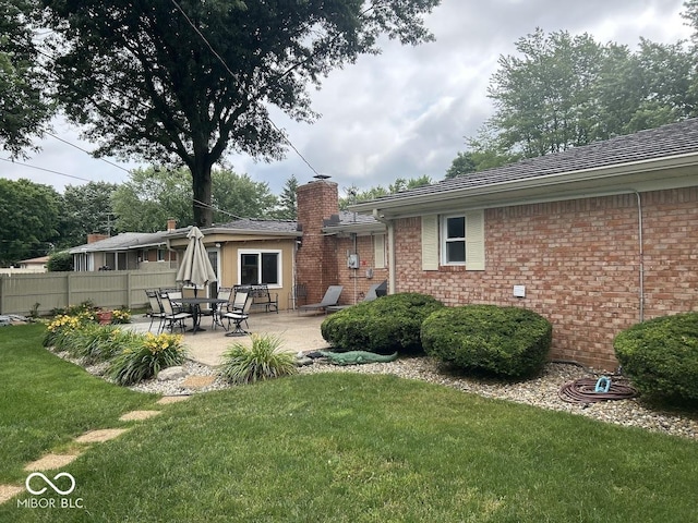4728 S Eaton Ave, Indianapolis, IN 46239 - rear view of property featuring a chimney, a patio area, and brick siding