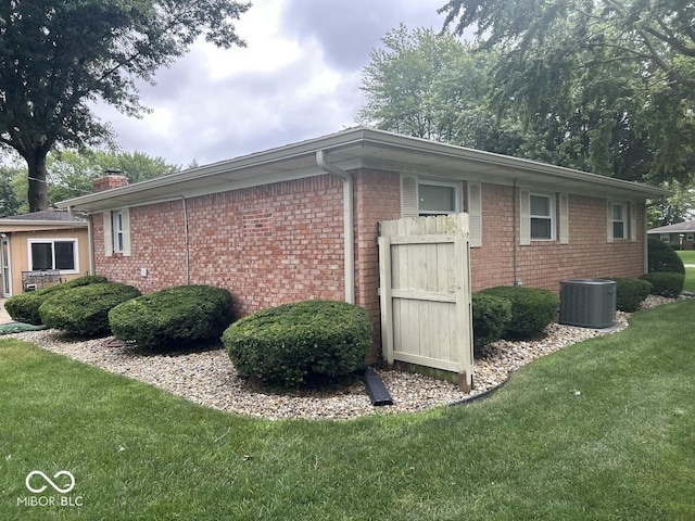 4728 S Eaton Ave, Indianapolis, IN 46239 - view of property exterior featuring a yard, brick siding, and a chimney