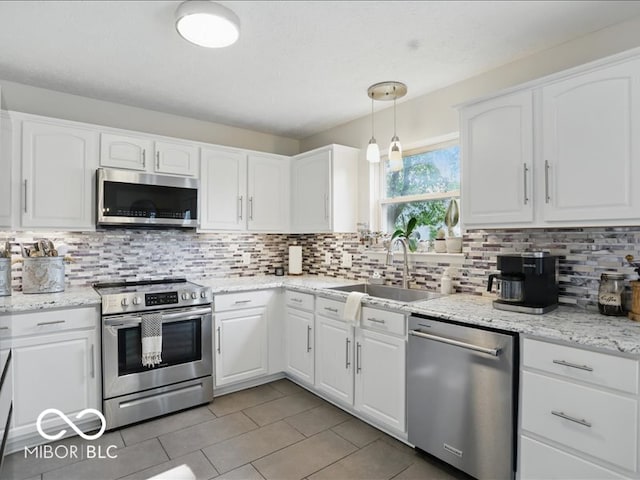 8508 Aviva Ln, Indianapolis, IN 46237 - kitchen featuring stainless steel appliances, white cabinetry, light tile patterned flooring, and tasteful backsplash