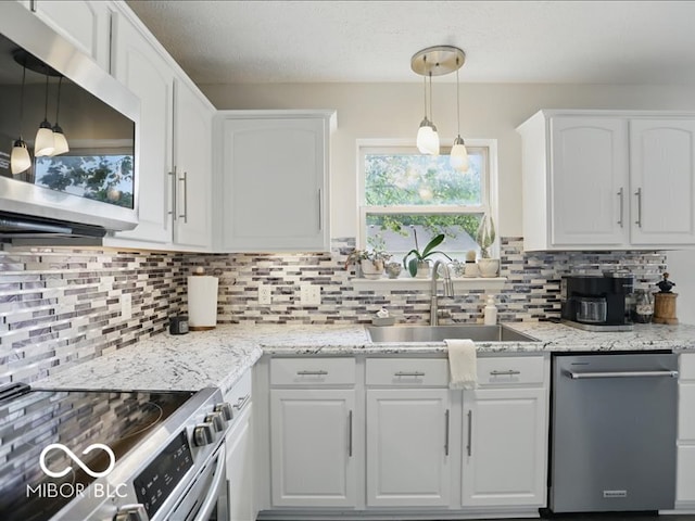 8508 Aviva Ln, Indianapolis, IN 46237 - kitchen featuring stainless steel appliances, white cabinetry, tasteful backsplash, and hanging light fixtures