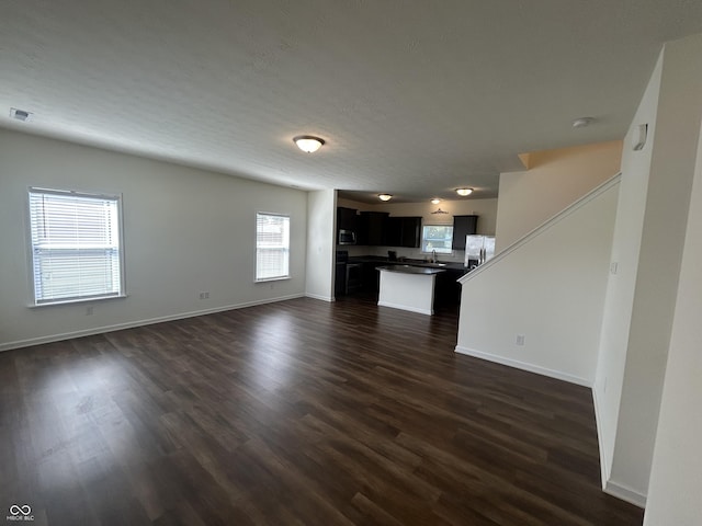 108 Herbert Ct, Trafalgar, IN 46181 - unfurnished living room featuring plenty of natural light and dark wood finished floors
