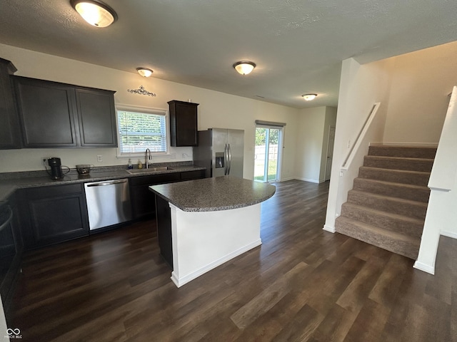 108 Herbert Ct, Trafalgar, IN 46181 - kitchen featuring stainless steel appliances, dark wood-style floors, a center island, and dark countertops