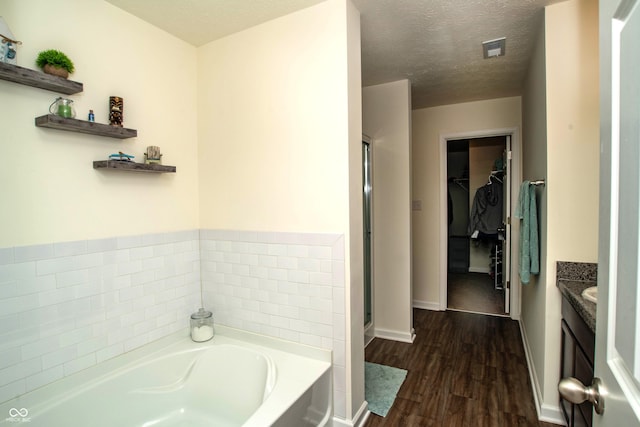 108 Herbert Ct, Trafalgar, IN 46181 - bathroom featuring a bath, vanity, a walk in closet, wood finished floors, and a shower stall