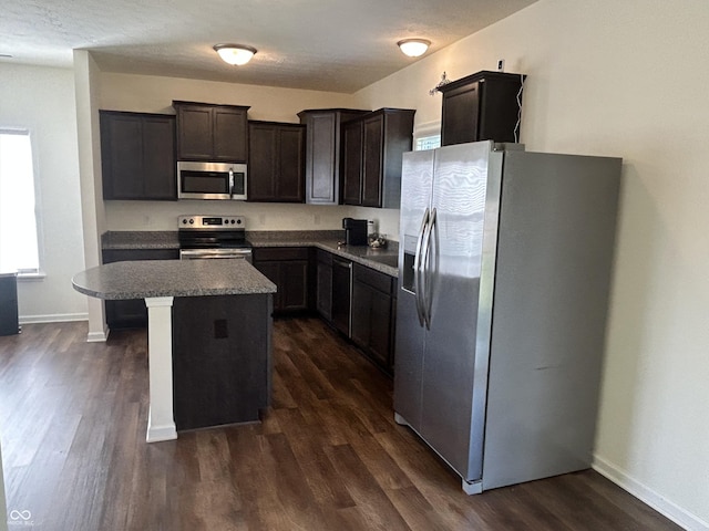 108 Herbert Ct, Trafalgar, IN 46181 - kitchen with appliances with stainless steel finishes, dark wood finished floors, a center island, and dark brown cabinets