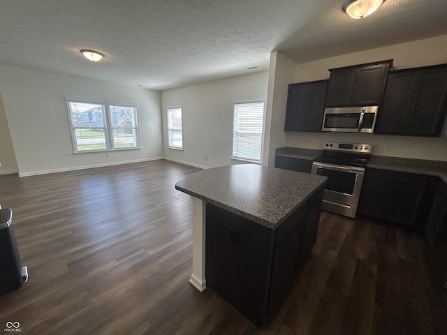 108 Herbert Ct, Trafalgar, IN 46181 - kitchen with stainless steel appliances, dark wood-style floors, a kitchen island, and dark countertops