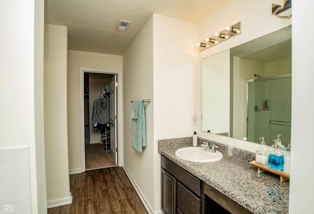 108 Herbert Ct, Trafalgar, IN 46181 - full bathroom featuring a shower stall, wood finished floors, vanity, and a walk in closet