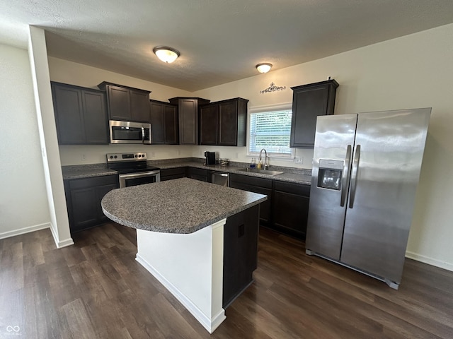 108 Herbert Ct, Trafalgar, IN 46181 - kitchen with stainless steel appliances, dark wood-style flooring, a center island, dark countertops, and dark brown cabinets