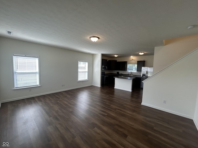 108 Herbert Ct, Trafalgar, IN 46181 - unfurnished living room featuring plenty of natural light and dark wood-style floors