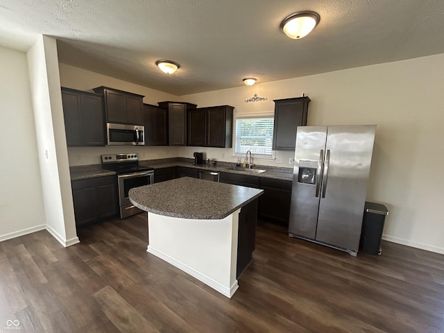 108 Herbert Ct, Trafalgar, IN 46181 - kitchen with stainless steel appliances, dark wood-type flooring, dark countertops, a kitchen island, and dark brown cabinets