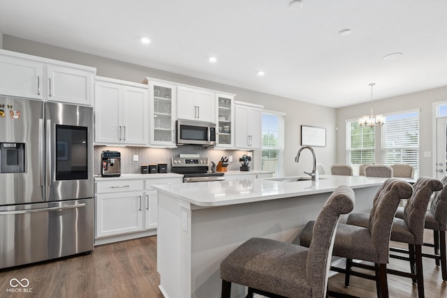 6330 Teakwood Way, Mccordsville, IN 46055 - kitchen with stainless steel appliances, a chandelier, a kitchen bar, dark wood-type flooring, and tasteful backsplash