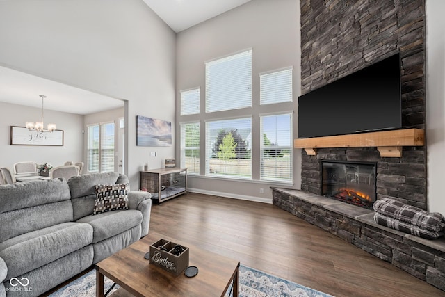 6330 Teakwood Way, Mccordsville, IN 46055 - living room featuring a chandelier, a stone fireplace, plenty of natural light, wood finished floors, and a high ceiling