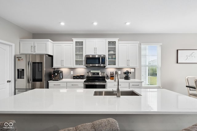 6330 Teakwood Way, Mccordsville, IN 46055 - kitchen featuring appliances with stainless steel finishes, decorative backsplash, a kitchen island with sink, light countertops, and recessed lighting