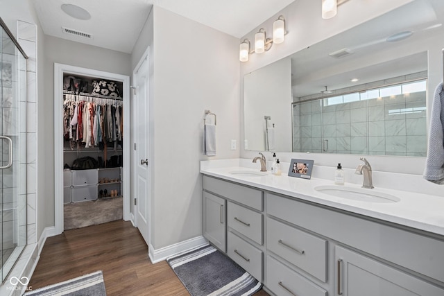 6330 Teakwood Way, Mccordsville, IN 46055 - full bathroom featuring a shower stall, double vanity, a walk in closet, and wood finished floors