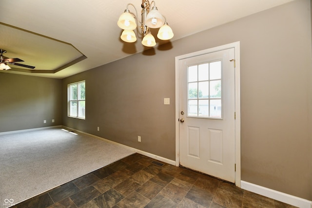 915 E Drybread Ln, Nineveh, IN 46164 - doorway featuring a chandelier, a ceiling fan, dark carpet, dark stone finish flooring, and a tray ceiling