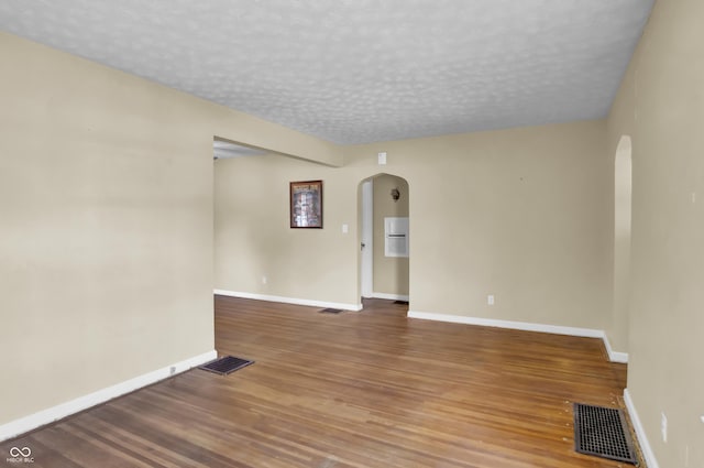 2433 17th St, Columbus, IN 47201 - unfurnished room with arched walkways, wood finished floors, and a textured ceiling