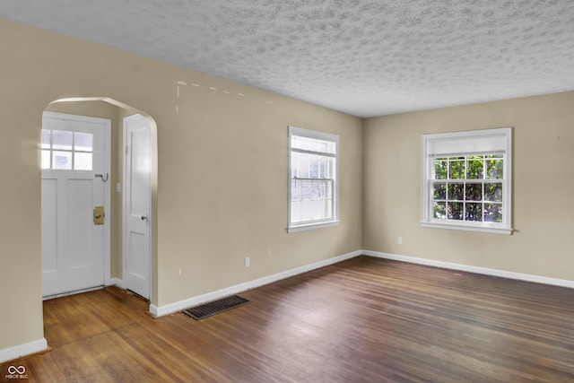 2433 17th St, Columbus, IN 47201 - spare room featuring arched walkways, wood finished floors, and a textured ceiling