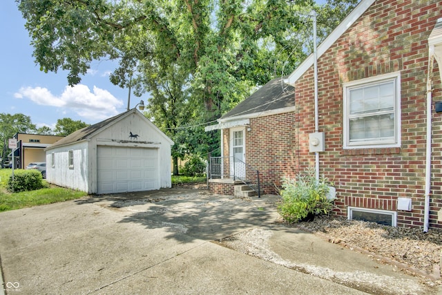 2433 17th St, Columbus, IN 47201 - view of home's exterior featuring driveway, an outbuilding, brick siding, and a detached garage
