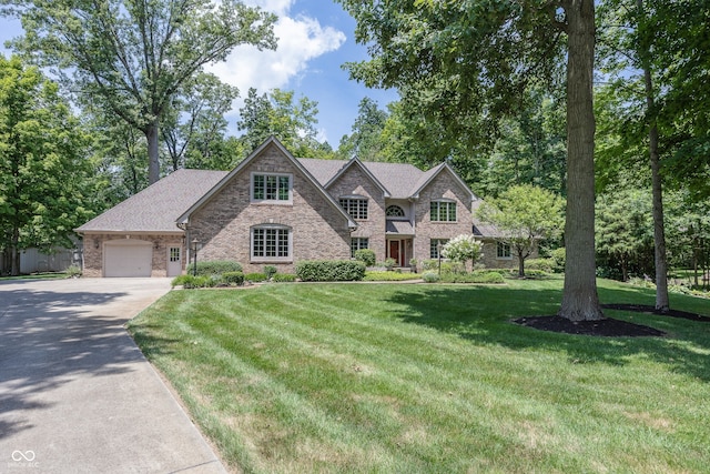 1112 N Dogwood Way, Greenfield, IN 46140 - view of front of property featuring driveway, a front lawn, brick siding, and a garage