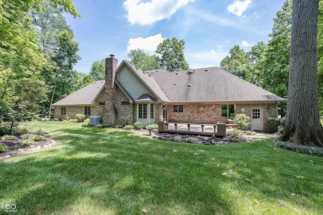 1112 N Dogwood Way, Greenfield, IN 46140 - rear view of house featuring a chimney, a wooden deck, a yard, brick siding, and roof with shingles