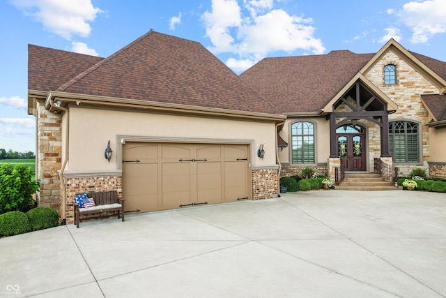 3075 Hurricane Rd, Franklin, IN 46131 - view of front of house with stone siding, concrete driveway, stucco siding, and french doors