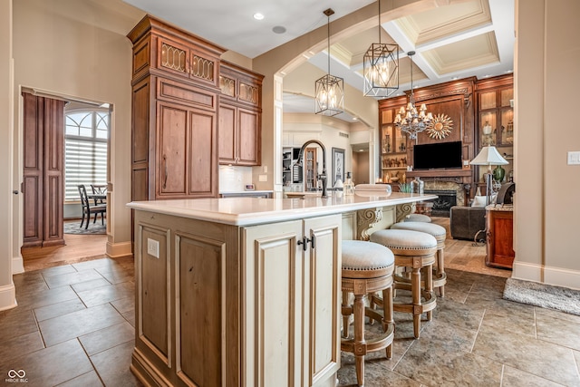 3075 Hurricane Rd, Franklin, IN 46131 - kitchen featuring open floor plan, arched walkways, light countertops, brown cabinetry, and a spacious island