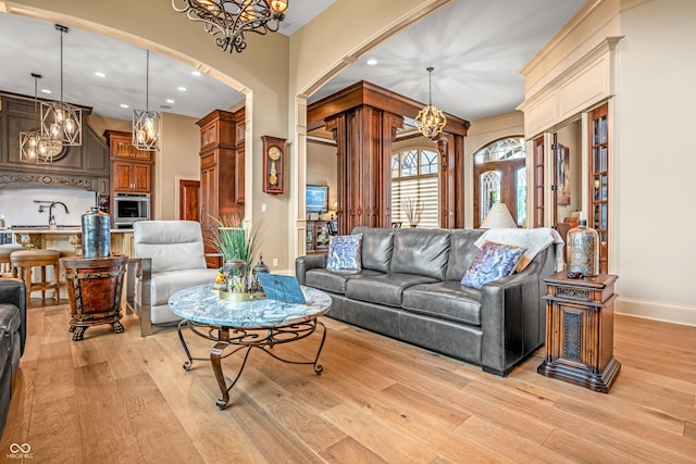 3075 Hurricane Rd, Franklin, IN 46131 - living room with a chandelier, arched walkways, recessed lighting, and light wood-style floors