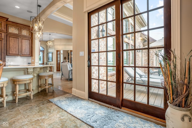 3075 Hurricane Rd, Franklin, IN 46131 - doorway to outside featuring healthy amount of natural light, crown molding, light stone finish flooring, a chandelier, and arched walkways