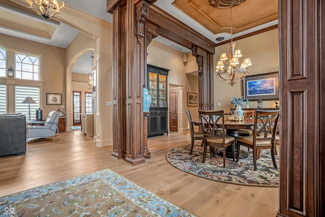 3075 Hurricane Rd, Franklin, IN 46131 - dining room featuring a chandelier, light wood-type flooring, crown molding, arched walkways, and a towering ceiling