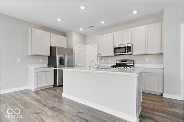 11431 Hartwell St, Indianapolis, IN 46235 - kitchen with appliances with stainless steel finishes, light wood finished floors, light countertops, a center island with sink, and recessed lighting